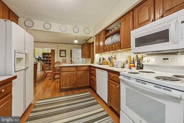 28 Cliff Rd, Front Royal, VA 22630 - kitchen featuring white appliances, light countertops, light wood-style flooring, brown cabinetry, and a peninsula