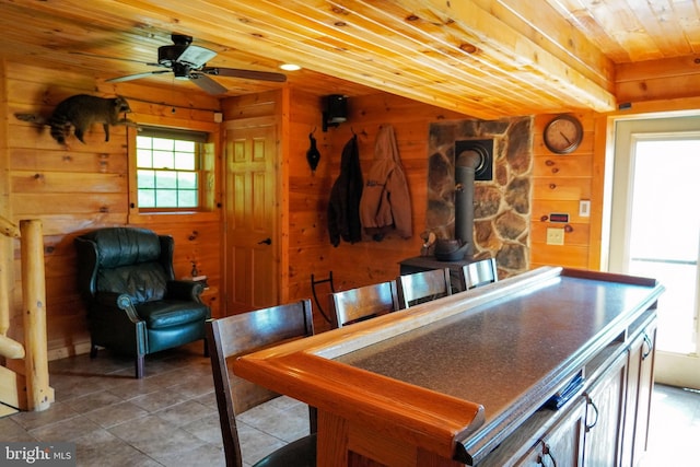 1870 General Potter Hwy, Centre Hall, PA 16828 - kitchen featuring wood ceiling, tile patterned floors, wood walls, ceiling fan, and a wood stove