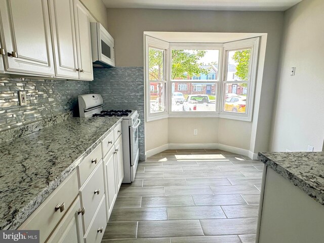 10105 Irongate Way, Manassas, VA 20109 - kitchen featuring white appliances, decorative backsplash, white cabinets, and light stone counters