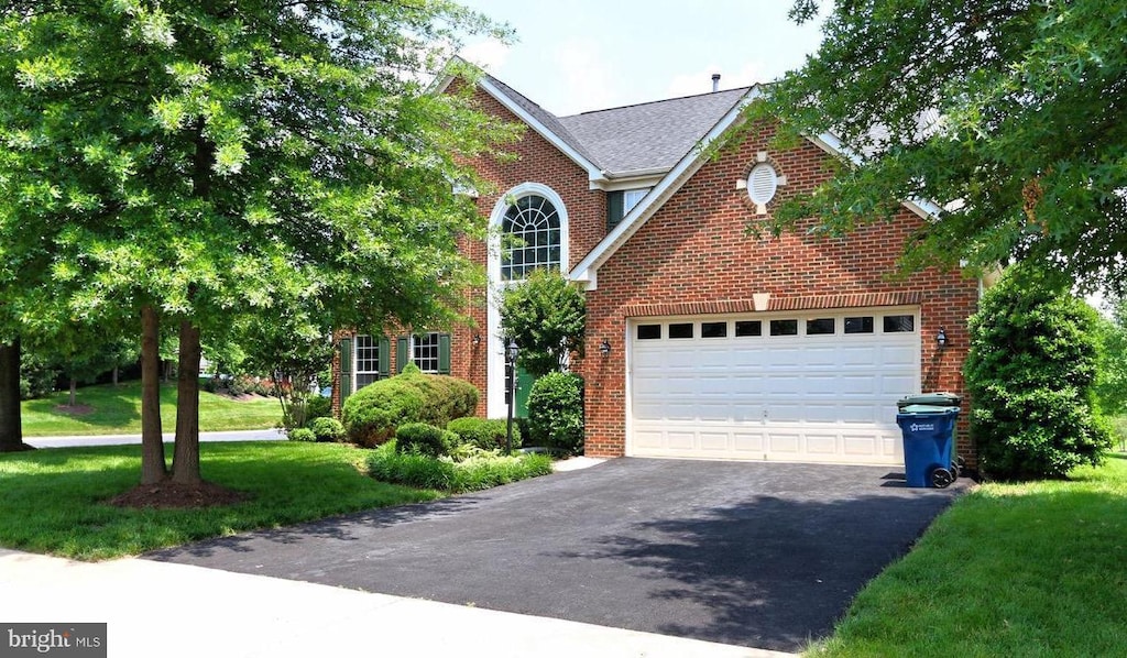 6901 Bitterroot Ct, Gainesville, VA 20155 - traditional home featuring asphalt driveway, brick siding, and a front yard