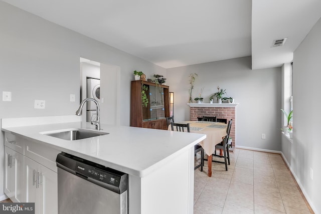 196 Saint Johns Sq, Sterling, VA 20164 - kitchen with dishwasher, light countertops, a fireplace, light tile patterned flooring, and white cabinetry