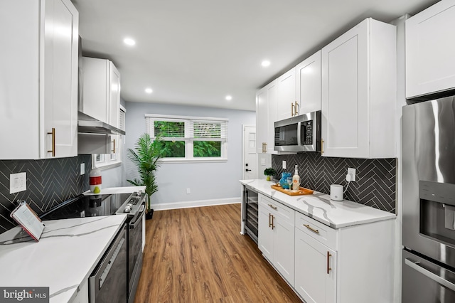 904 Stevenson Ln, Towson, MD 21286 - kitchen with stainless steel appliances, wood finished floors, white cabinetry, and recessed lighting