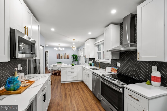 904 Stevenson Ln, Towson, MD 21286 - kitchen with appliances with stainless steel finishes, wall chimney exhaust hood, tasteful backsplash, wood finished floors, and a peninsula