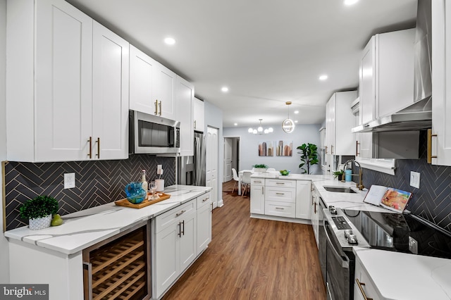 904 Stevenson Ln, Towson, MD 21286 - kitchen with stainless steel appliances, wine cooler, a peninsula, wood finished floors, and white cabinetry