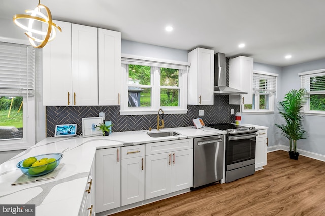 904 Stevenson Ln, Towson, MD 21286 - kitchen featuring wall chimney exhaust hood, stainless steel appliances, white cabinetry, backsplash, and light stone counters