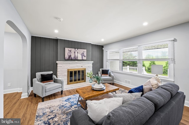 904 Stevenson Ln, Towson, MD 21286 - living room featuring arched walkways, a stone fireplace, wood finished floors, and recessed lighting