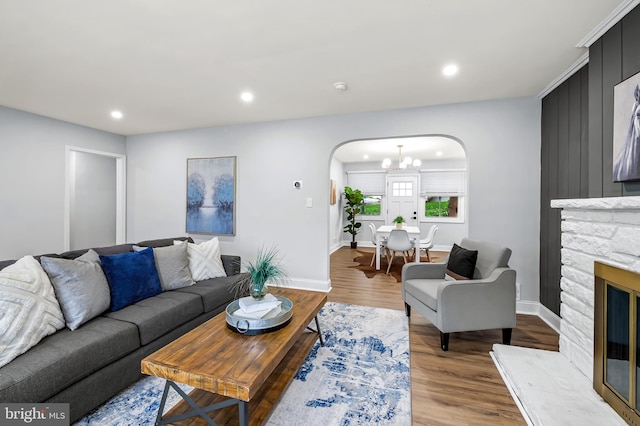 904 Stevenson Ln, Towson, MD 21286 - living room featuring arched walkways, wood finished floors, recessed lighting, a stone fireplace, and a chandelier