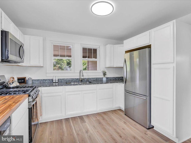 69 Mary Elmer Dr, Bridgeton, NJ 08302 - kitchen with appliances with stainless steel finishes, white cabinetry, dark stone counters, and light wood finished floors