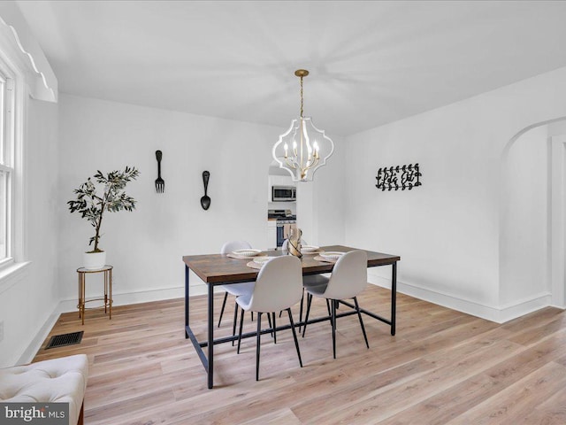 69 Mary Elmer Dr, Bridgeton, NJ 08302 - dining area featuring light wood finished floors, a chandelier, and arched walkways