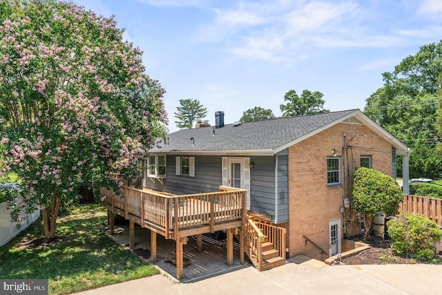 1121 Collingwood Rd, Alexandria, VA 22308 - rear view of house with a wooden deck, a patio, brick siding, and a chimney