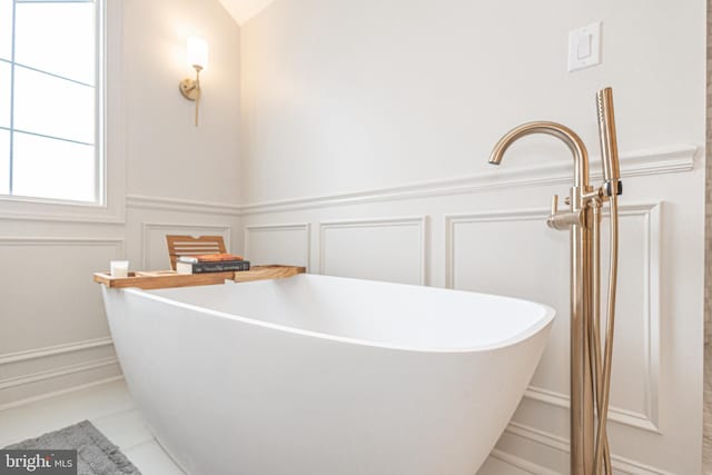405 Hoffman Rd, Harleysville, PA 19438 - bathroom with a decorative wall, a freestanding tub, a wainscoted wall, and tile patterned flooring