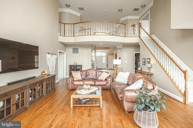 405 Hoffman Rd, Harleysville, PA 19438 - living area featuring wood finished floors, stairs, a towering ceiling, and ornamental molding