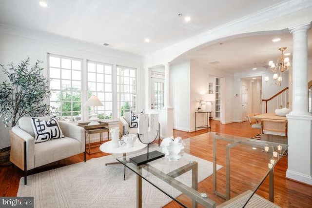 409 S Henry St, Alexandria, VA 22314 - living room with arched walkways, wood finished floors, decorative columns, crown molding, and a chandelier