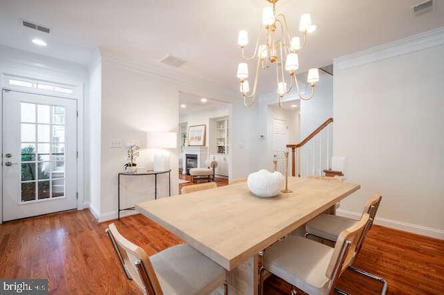 409 S Henry St, Alexandria, VA 22314 - dining area featuring wood finished floors, ornamental molding, a chandelier, and a fireplace