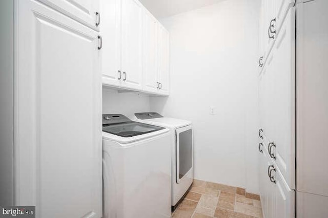 409 S Henry St, Alexandria, VA 22314 - laundry room with washer and clothes dryer, light stone finish flooring, and cabinet space