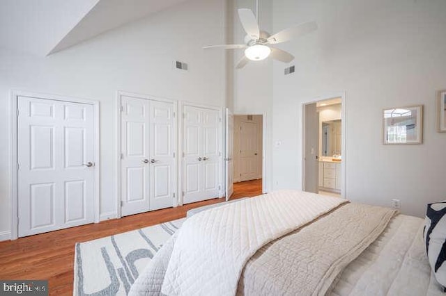 409 S Henry St, Alexandria, VA 22314 - bedroom with two closets, high vaulted ceiling, wood finished floors, ensuite bath, and ceiling fan