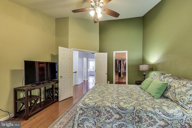 4174 La Mauricie Loop, Dumfries, VA 22025 - bedroom featuring wood finished floors, a spacious closet, a towering ceiling, ceiling fan, and a closet