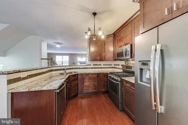 4174 La Mauricie Loop, Dumfries, VA 22025 - kitchen with appliances with stainless steel finishes, dark wood-style floors, decorative backsplash, light stone counters, and a peninsula