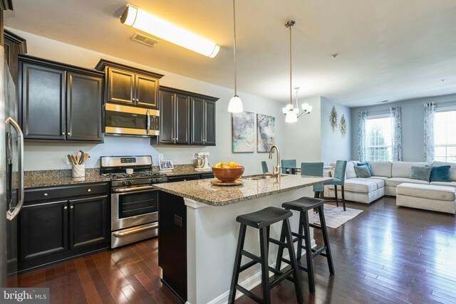 9423 Geaton Park Pl, Lanham, MD 20706 - kitchen with stainless steel appliances, dark wood-type flooring, light stone countertops, a chandelier, and open floor plan