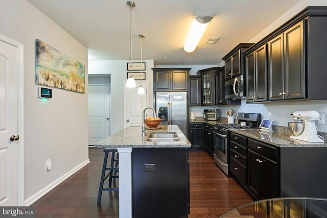 9423 Geaton Park Pl, Lanham, MD 20706 - kitchen featuring appliances with stainless steel finishes, light stone countertops, a kitchen bar, glass insert cabinets, and dark wood-style floors