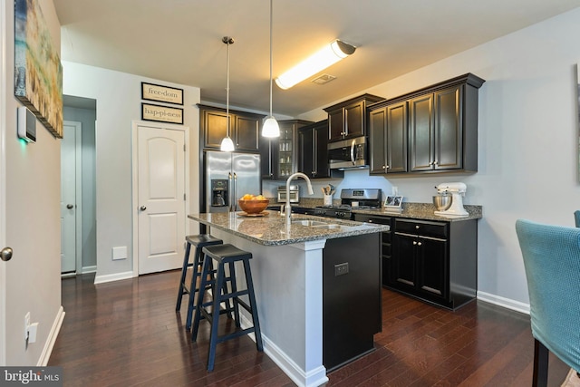 9423 Geaton Park Pl, Lanham, MD 20706 - kitchen featuring appliances with stainless steel finishes, stone countertops, dark wood-style floors, and a breakfast bar