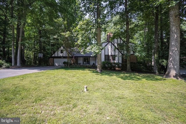 553 Choptank Cove Ct, Annapolis, MD 21401 - tudor house featuring driveway, a chimney, a front lawn, and a garage