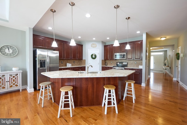 722 Cherry Tree Rd, Middletown, DE 19709 - kitchen with stainless steel appliances, backsplash, light wood finished floors, a kitchen breakfast bar, and a large island