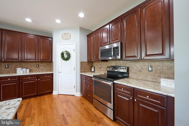 722 Cherry Tree Rd, Middletown, DE 19709 - kitchen featuring appliances with stainless steel finishes, light wood-style flooring, light stone counters, tasteful backsplash, and recessed lighting