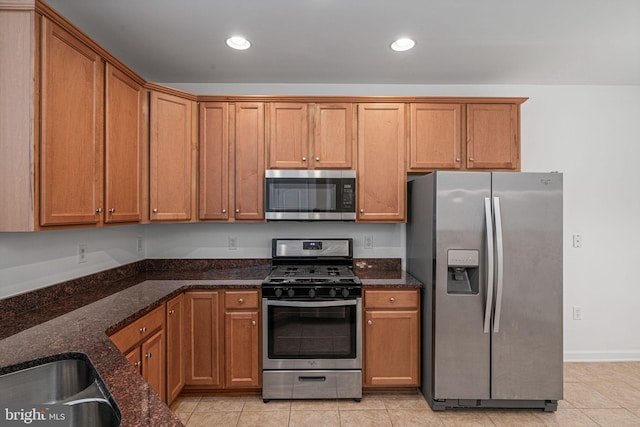 9713 Handerson Pl Unit 203, Manassas Park, VA 20111 - kitchen featuring appliances with stainless steel finishes, dark stone counters, recessed lighting, light tile patterned flooring, and brown cabinets