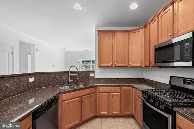 9713 Handerson Pl Unit 203, Manassas Park, VA 20111 - kitchen with stainless steel appliances, dark stone countertops, brown cabinets, light tile patterned flooring, and crown molding