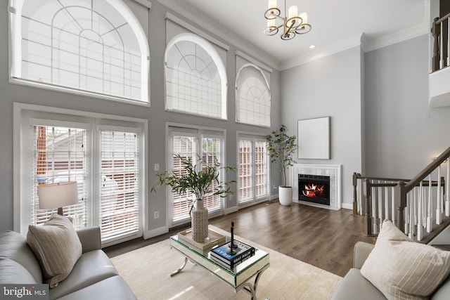 2517 Hunton Pl, Alexandria, VA 22311 - living area featuring ornamental molding, a warm lit fireplace, wood finished floors, a chandelier, and stairs