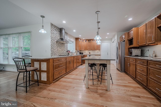 310 Belmont Ct, Lincoln University, PA 19352 - kitchen featuring wall chimney range hood, a kitchen bar, plenty of natural light, light wood-style flooring, and recessed lighting