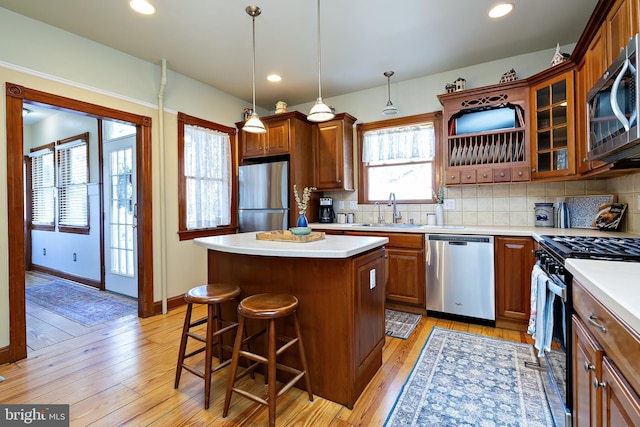902 Station Ave, Haddon Heights, NJ 08035 - kitchen with stainless steel appliances, a kitchen island, light countertops, a kitchen bar, and decorative backsplash