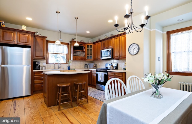 902 Station Ave, Haddon Heights, NJ 08035 - kitchen with stainless steel appliances, light wood-type flooring, a kitchen island, glass insert cabinets, and light countertops