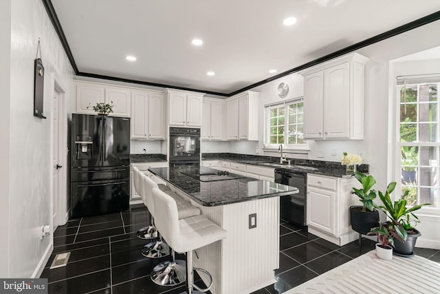 4305 Mulcaster Ter, Dumfries, VA 22025 - kitchen with black appliances, white cabinetry, ornamental molding, recessed lighting, and a center island
