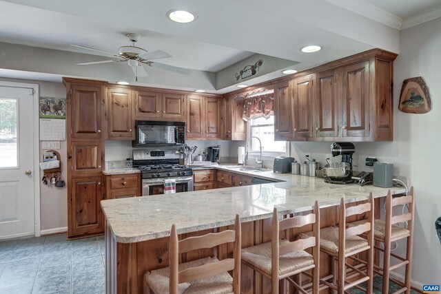 1505 Running Deer Dr, Keswick, VA 22947 - kitchen with black microwave, gas range, a peninsula, ornamental molding, and ceiling fan