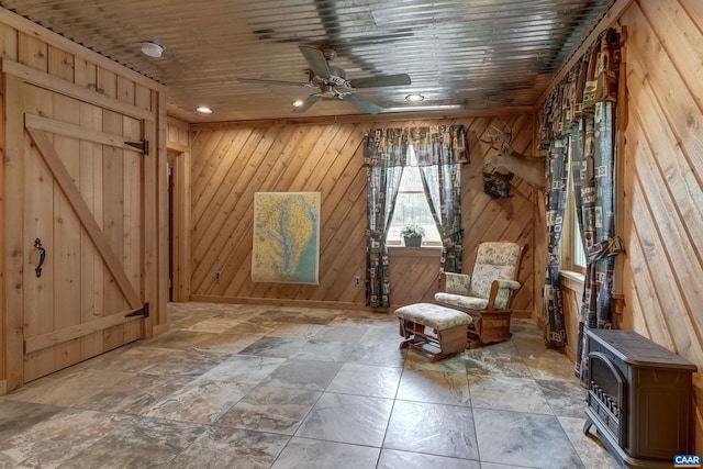 1505 Running Deer Dr, Keswick, VA 22947 - living area featuring a ceiling fan, wood walls, and a wood stove
