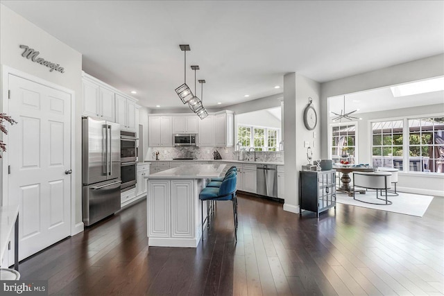 22 Thomas Speakman Dr Unit 76, Glen Mills, PA 19342 - kitchen featuring appliances with stainless steel finishes, light countertops, backsplash, a kitchen bar, and recessed lighting