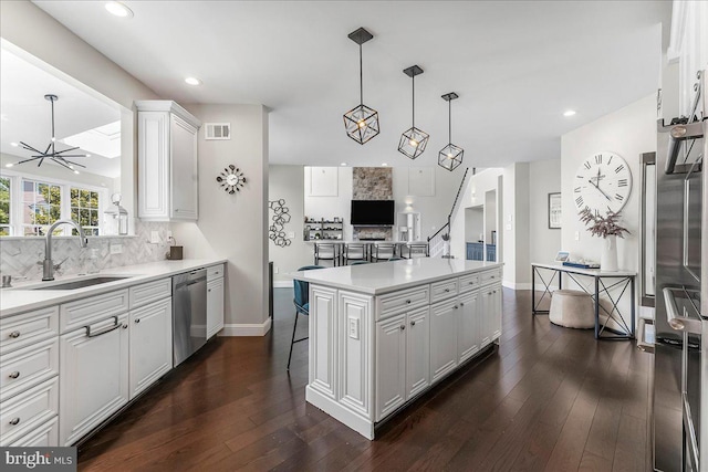 22 Thomas Speakman Dr Unit 76, Glen Mills, PA 19342 - kitchen featuring stainless steel dishwasher, decorative backsplash, white cabinetry, light countertops, and dark wood-type flooring