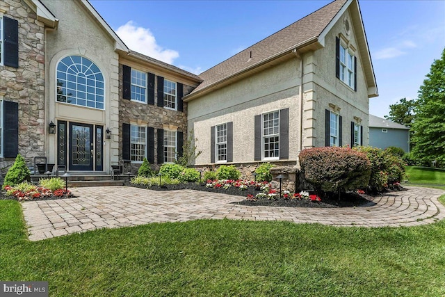 22 Thomas Speakman Dr Unit 76, Glen Mills, PA 19342 - rear view of house with stone siding, stucco siding, and a yard