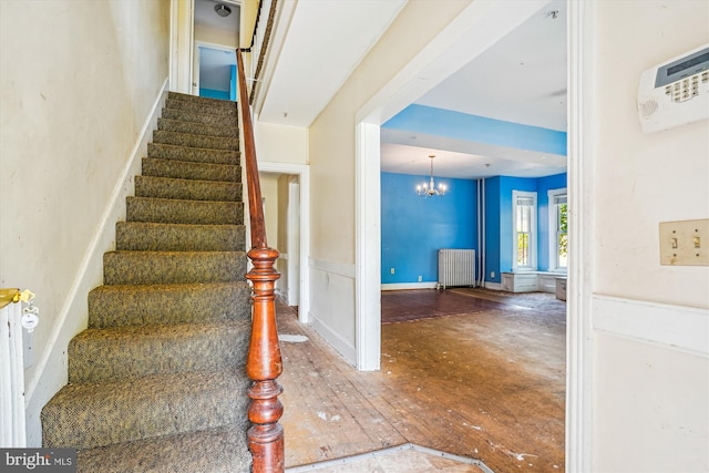 209 E Broad St, Falls Church, VA 22046 - stairway featuring radiator heating unit, a chandelier, and hardwood / wood-style floors