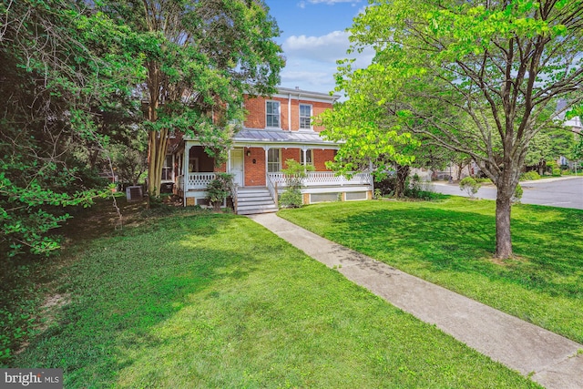 209 E Broad St, Falls Church, VA 22046 - view of front of house featuring brick siding, covered porch, and a front yard