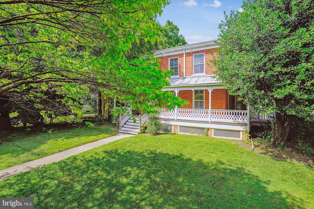 209 E Broad St, Falls Church, VA 22046 - view of front of house featuring brick siding, a front lawn, and a standing seam roof