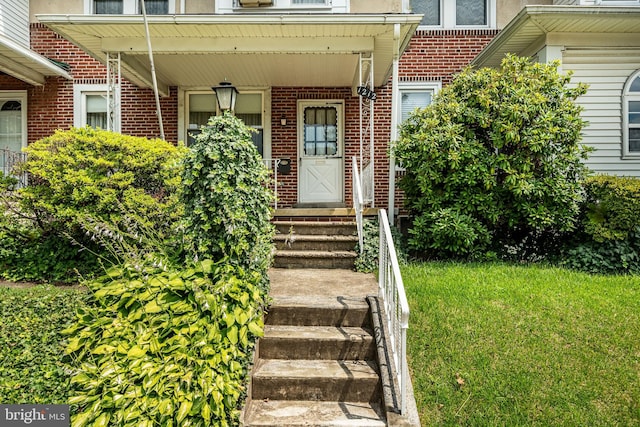 1212 Astor St, Norristown, PA 19401 - doorway to property featuring brick siding and a lawn