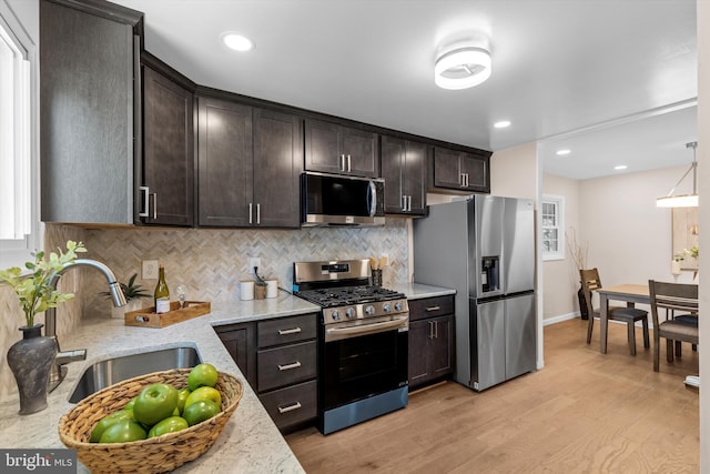 423 Highmeadow Rd, Reisterstown, MD 21136 - kitchen with stainless steel appliances, tasteful backsplash, dark brown cabinetry, light wood-type flooring, and light stone countertops