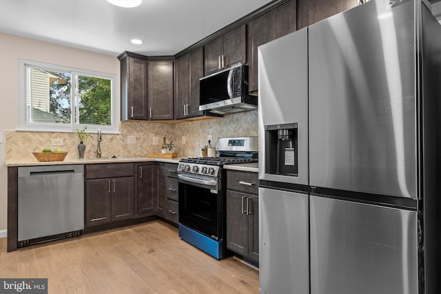 423 Highmeadow Rd, Reisterstown, MD 21136 - kitchen featuring appliances with stainless steel finishes, dark brown cabinetry, light wood-style floors, light countertops, and tasteful backsplash