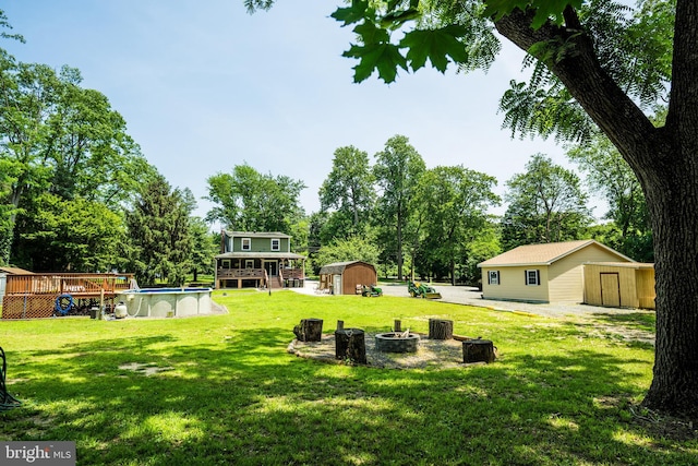 674 Good Intent Rd, Blackwood, NJ 08012 - view of grassy yard featuring a shed, an outdoor fire pit, a deck, an outdoor pool, and view of scattered trees