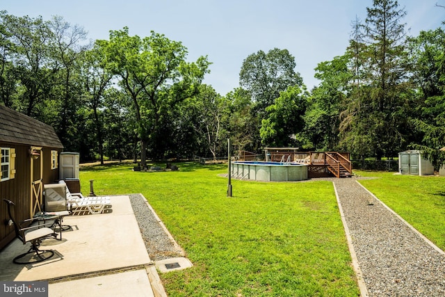 674 Good Intent Rd, Blackwood, NJ 08012 - view of green lawn with a storage shed, a wooden deck, an outdoor pool, a patio, and view of scattered trees