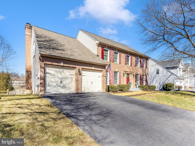 6108 Fieldcrest Dr, Frederick, MD 21701 - colonial home with brick siding, a garage, a chimney, driveway, and a front yard