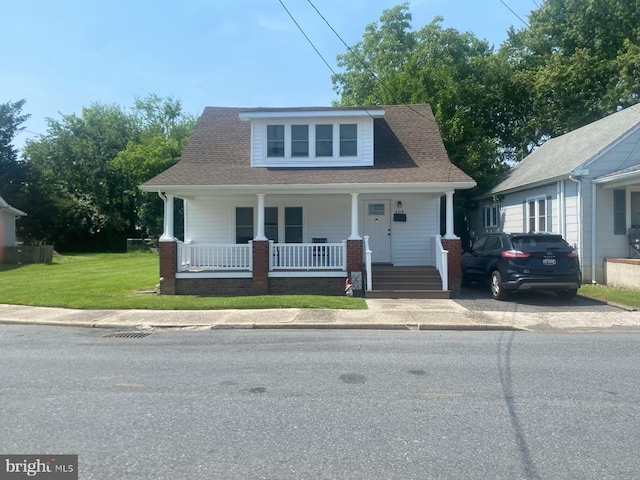 404 Phillips Ave, Cambridge, MD 21613 - bungalow-style home with a porch, a front lawn, and a shingled roof